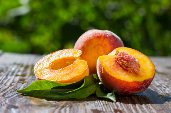 Freshly cut peaches on a wooden table.